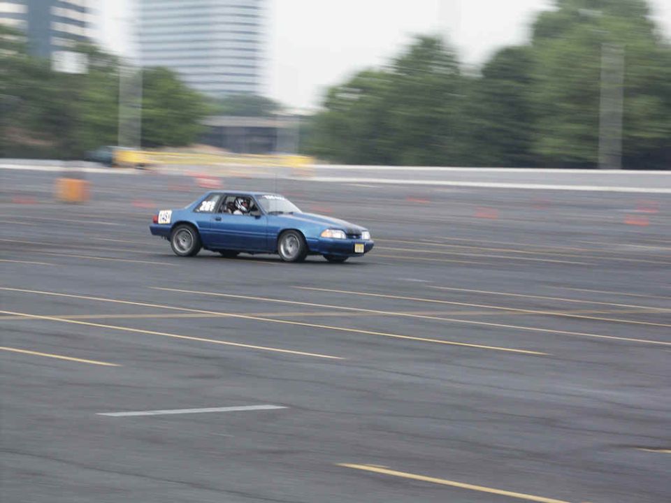 Blue 1987 Ford Mustang on race track, side view. Number 45 visible