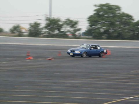2001 Mercury Grand Marquis - A blue 1993 Ford Mustang coupe is seen on a track, likely participating in a motorsports event.