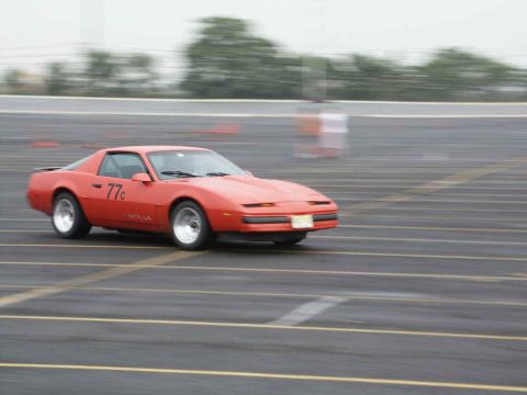 2001 Mercury Grand Marquis - A red Pontiac Firebird is seen on a track, possibly during a race or autocross event.