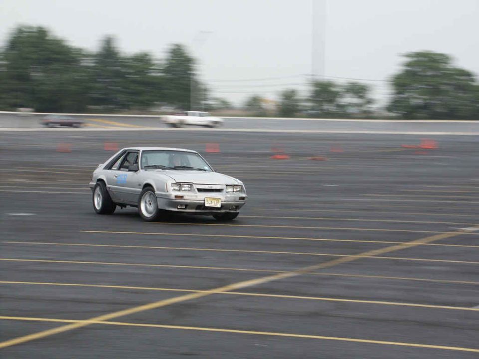 Silver Ford Mustang on a track, possibly during a race or autocross event