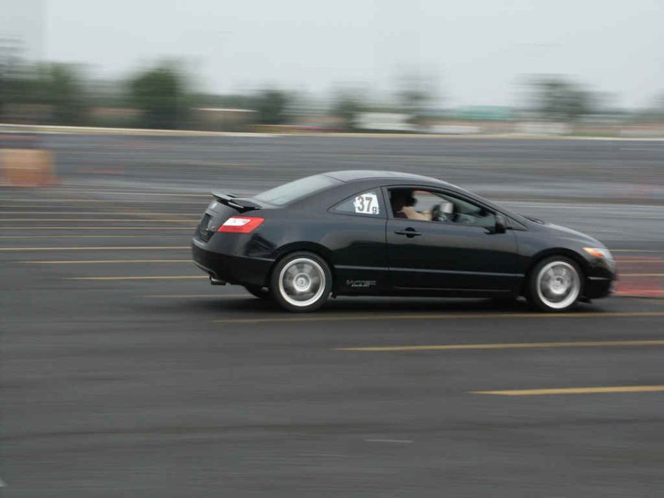 Black coupe with racing number 37 on the door, moving on a track