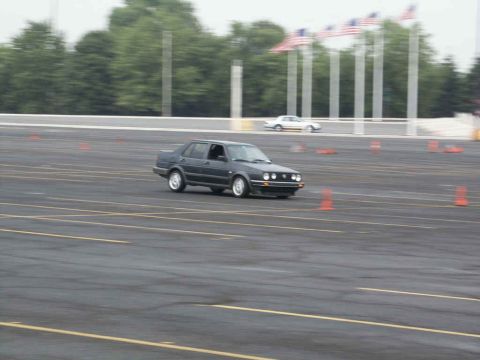 2001 Mercury Grand Marquis - A dark sedan navigates a course marked by cones, with another vehicle visible in the distance.