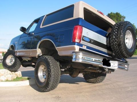 1996 Ford Bronco - This lifted 1996 Ford Bronco is shown from the rear 3/4 view with a spare tire on the back.