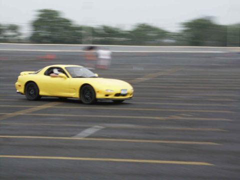 2001 Mercury Grand Marquis - A yellow sports car navigates a track with motion blur.