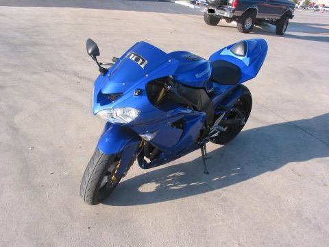 1996 Ford Bronco - A blue Kawasaki sportbike is parked on concrete, with a blue Ford Bronco in the background.