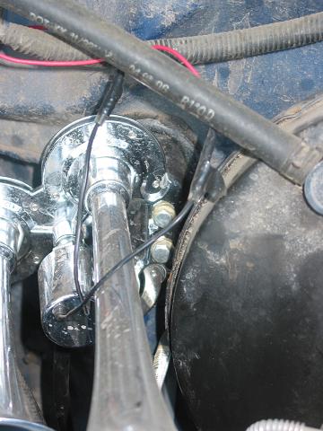 1996 Ford Bronco - Close-up of a chrome train horn assembly, showing wiring and a black hose with text.