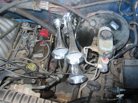 1996 Ford Bronco - Engine bay with aftermarket train horns installed. Year and make unknown.