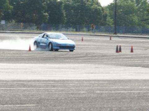 2001 Mercury Grand Marquis - A blue Toyota MR2 is seen drifting during an event, kicking up dust.