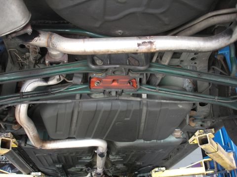 1993 Ford Taurus - The undercarriage of a vehicle is shown, the fuel tank and exhaust system.