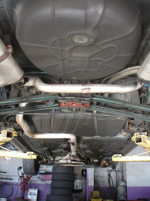 1993 Ford Taurus - The underside of a vehicle is viewed from below, revealing its mechanical components and undercarriage.