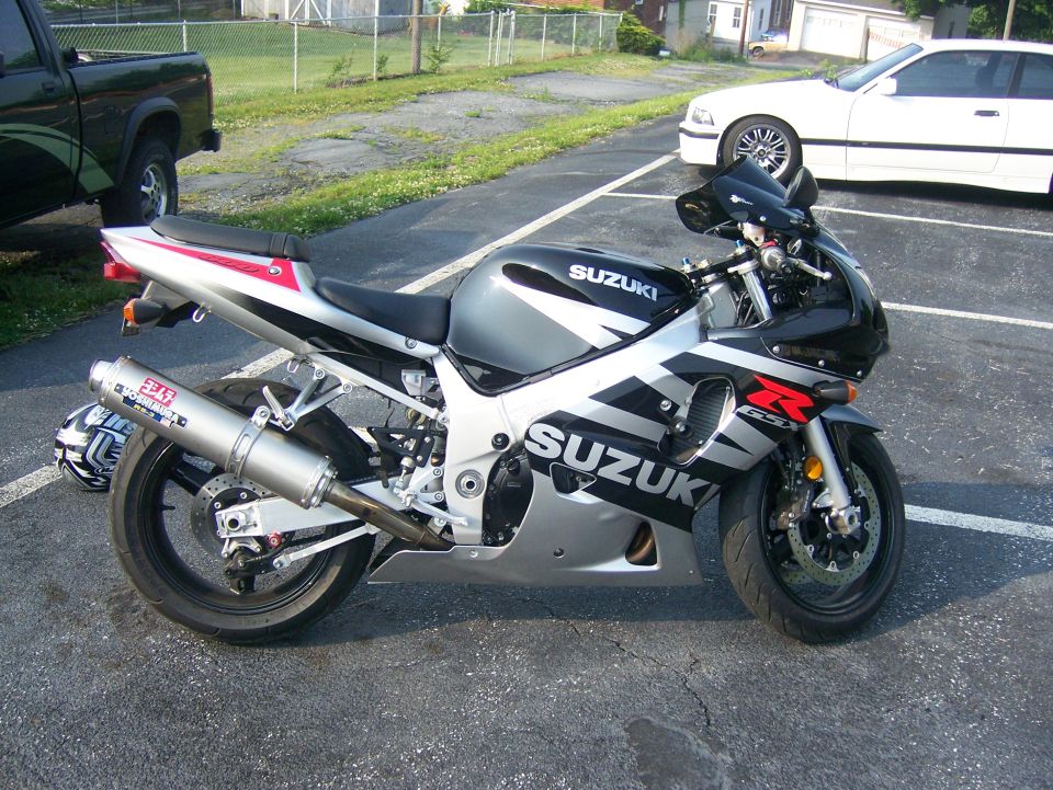 Black and silver Suzuki GSX-R sportbike with Yoshimura exhaust in a parking lot