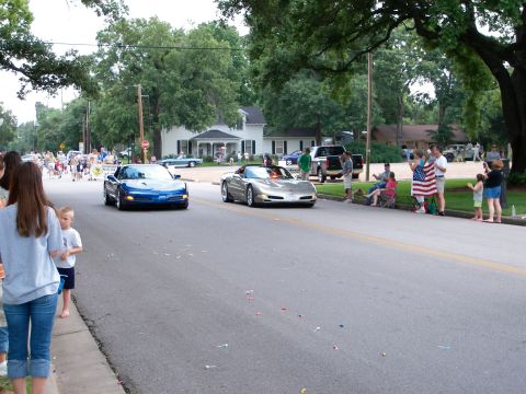 2000 Ford Crown Victoria - Spectators line the street to watch two Corvettes participate in a parade.