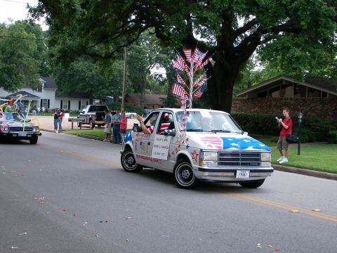 2000 Ford Crown Victoria - A decorated minivan participates in a parade, with another vehicle visible in the background.