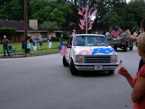 2000 Ford Crown Victoria - A decorated van participates in a parade, with spectators watching from the sidewalk.