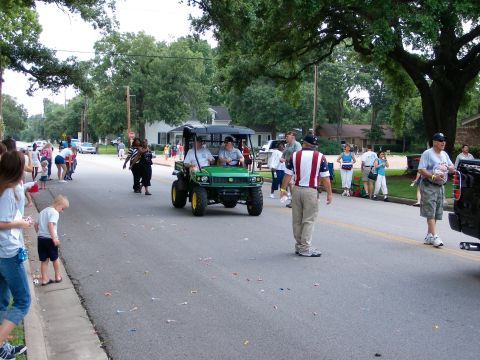 2000 Ford Crown Victoria - People watch a parade as a utility vehicle drives by on a suburban street.