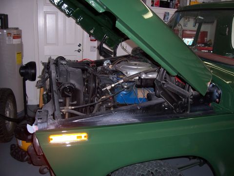 1978 Ford Bronco - The engine bay of a 1978 Ford Bronco is visible with the hood raised.