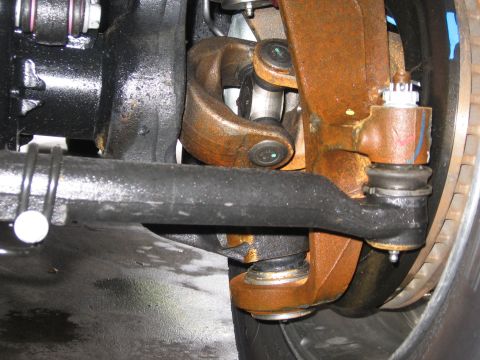 1974 Ford F-100 - Close-up view of vehicle steering and suspension parts, showing significant rust and wear on metal components.