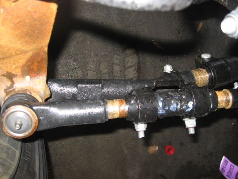 1974 Ford F-100 - Close-up of a vehicle's steering linkage components, showing wear and some surface rust.