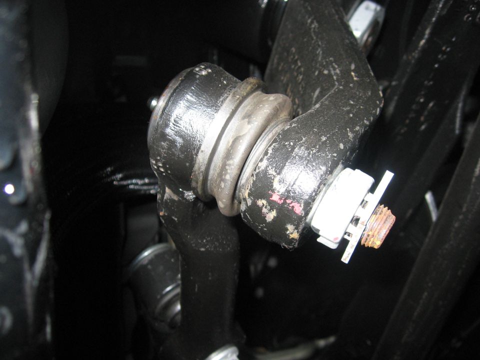 Close-up of steering linkage with a cotter pin and nut