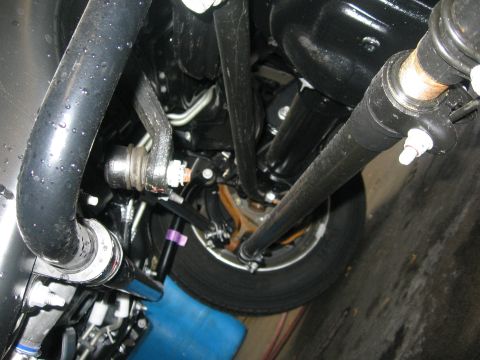 1974 Ford F-100 - Close-up of steering and suspension components under a vehicle.