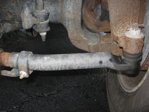 1974 Ford F-100 - Close-up view of a vehicle's steering linkage and suspension components, showing signs of rust and wear.