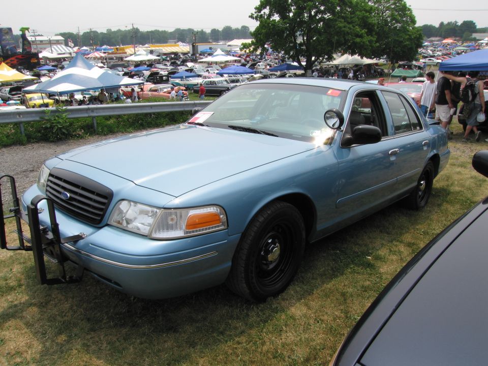 Light blue 1991 Ford Crown Victoria LTD with push bar parked on grass at an outdoor event