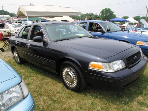1991 Ford LTD Crown Victoria - Two Ford Crown Victorias are parked on grass at an outdoor event.