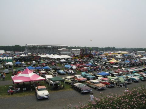 1991 Ford LTD Crown Victoria - A wide view of a car show with numerous vehicles and spectators gathered.