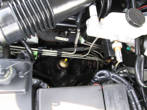 1991 Ford LTD Crown Victoria - Close-up view of an engine bay, showing the brake fluid reservoir, air intake system, and various hoses and wiring.