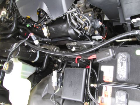 1991 Ford LTD Crown Victoria - Close-up of a vehicle's engine bay, the battery and a Ford-branded fuse box.