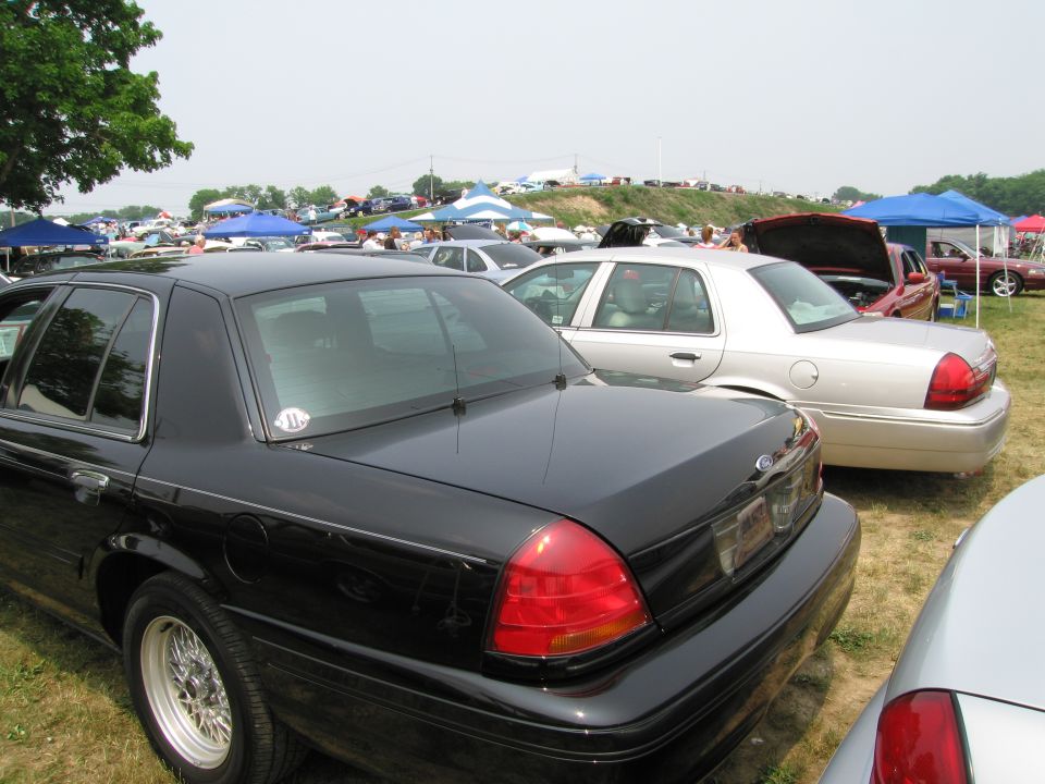 Black sedan's rear quarter panel and taillight, with a silver sedan behind it