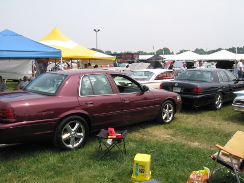 1991 Ford LTD Crown Victoria - A maroon sedan is parked on the grass at an outdoor event, with a black sedan also visible in the background.