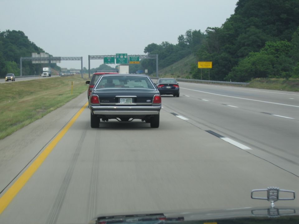 1991 Ford Crown Victoria LTD driving on highway, rear view. License plate 219-ABHZ