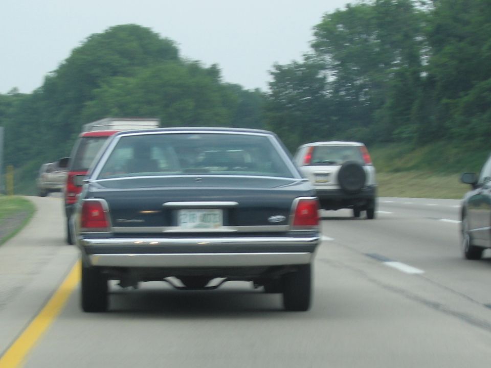 Dark blue sedan rear view on highway, license plate 218 4072
