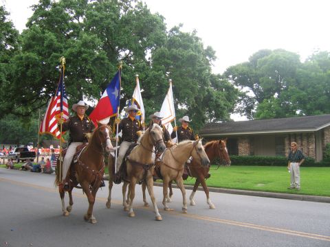 2000 Ford Crown Victoria - Officers on horseback participate in a parade, carrying American and Texas flags.