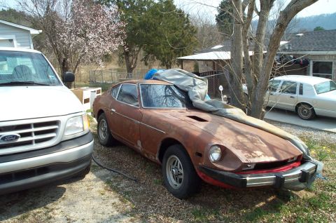 1988 Ford Bronco - A weathered Datsun 280Z sits in a yard next to a Ford van, with a white sedan visible behind a tree.