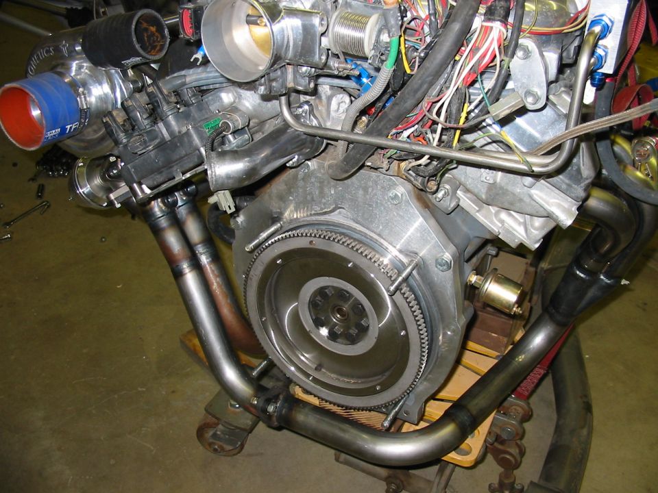 Engine with turbocharger, exhaust manifold, and wiring harness. Visible text: SUPERMOTORS