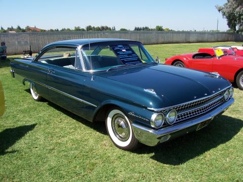 2002 Ford Mustang - This 1961 Ford Fairlane 500 Skyliner coupe is displayed on a grassy field with a red sports car in the background.