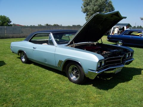 2002 Ford Mustang - A classic light blue coupe is displayed with its hood open, the engine bay, with another vehicle in the background.