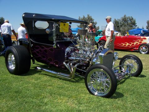 2002 Ford Mustang - Custom hot rod with a prominent V8 engine and flame graphics, displayed outdoors.