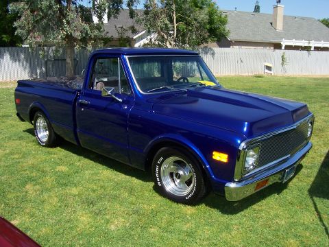 2002 Ford Mustang - A blue pickup truck with a chrome grille and bumper is parked on a grassy lawn.