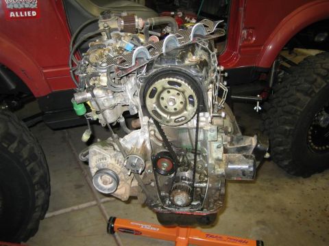 1987 Suzuki Samurai - The engine has been removed from the vehicle and is supported by an engine stand for maintenance or replacement.