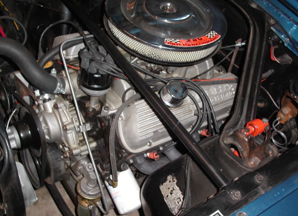 1965 Ford Mustang engine bay with V8 engine, chrome air cleaner, and blue paint