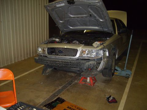 2004 Ford Crown Victoria - Front view of a 2004 Ford Crown Victoria undergoing maintenance with its hood raised.
