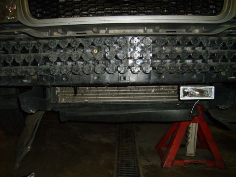 2004 Ford Crown Victoria - The front of a vehicle is shown with the grille removed, exposing the radiator and a fog light installation.