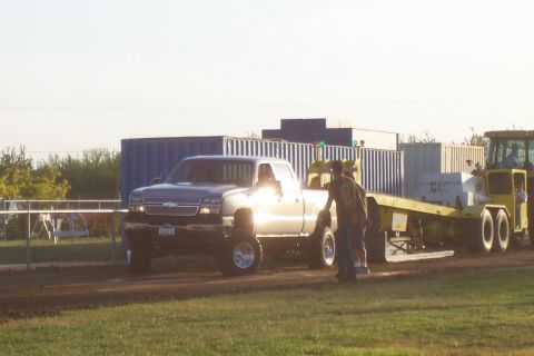 1994 Ford F-150 - Silver Chevrolet Silverado pickup truck is seen towing a trailer with two people nearby.