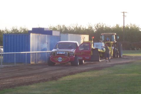 1994 Ford F-150 - Truck and tractor at a competition event on a dirt track.