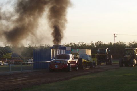 1994 Ford F-150 - A modified pickup truck competes in a pull event, generating significant exhaust smoke.