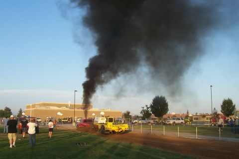 1994 Ford F-150 - A truck emits a large plume of black smoke during a pull event, with spectators gathered.