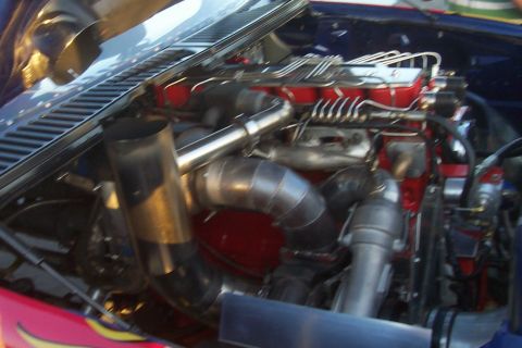 1994 Ford F-150 - Close-up of a modified truck engine bay, showing turbocharger and exhaust piping.